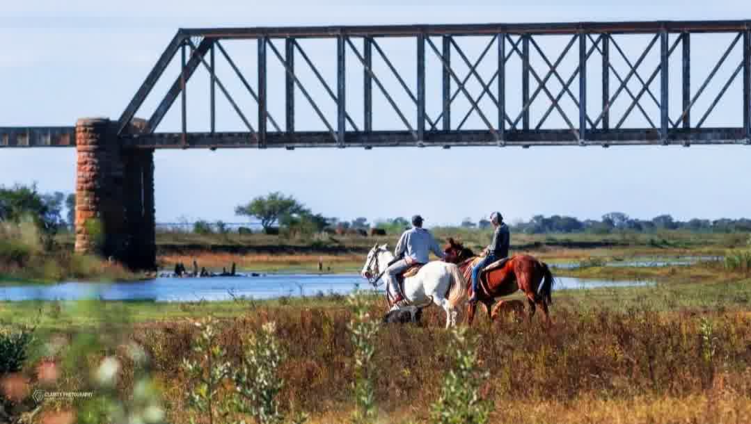 Jinetes junto a las pilas de mampostería del puente